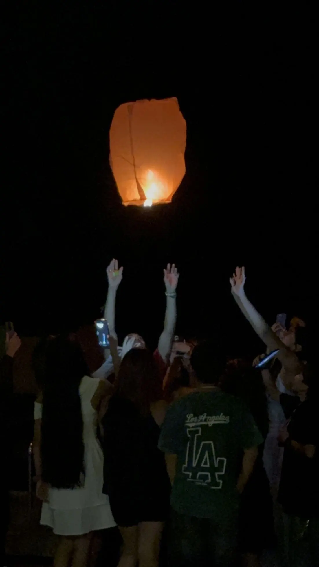 Campistas sueltan un globo de luz en la noche
