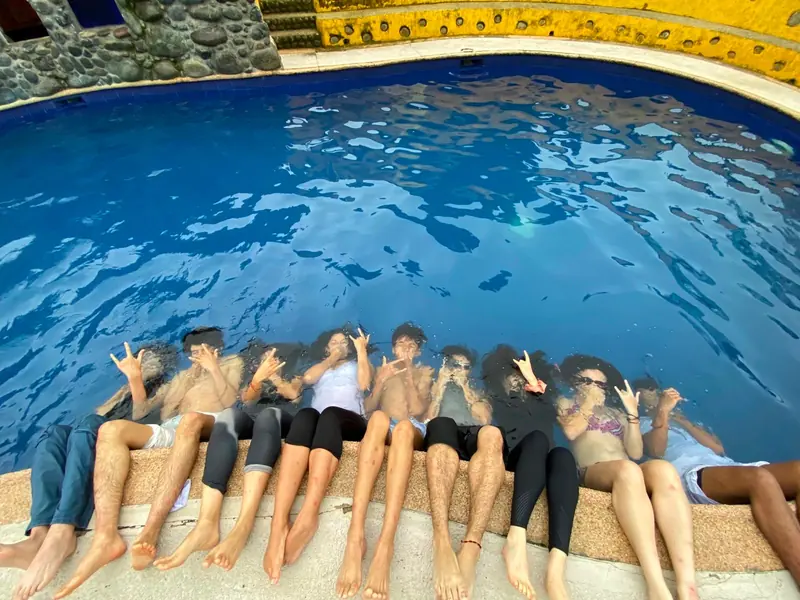 Campistas sentados al borde de la piscina