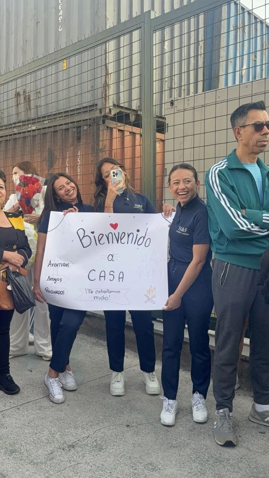 Familias reciben a los campistas con un cartel de bienvenida a casa